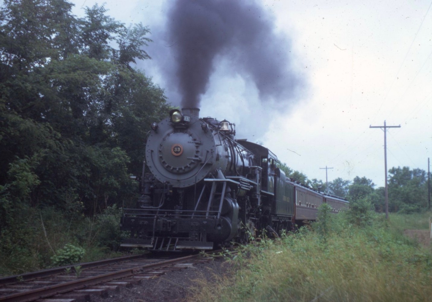 a steam engine is on a train track with smoke coming out of it