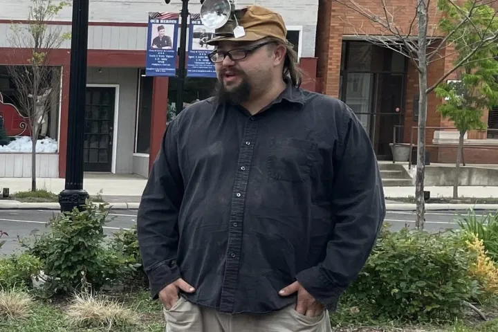 a man standing in front of a brick building